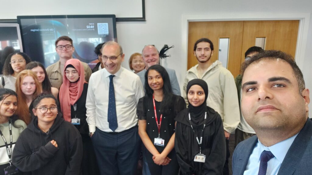 Group of students with staff and parliament official