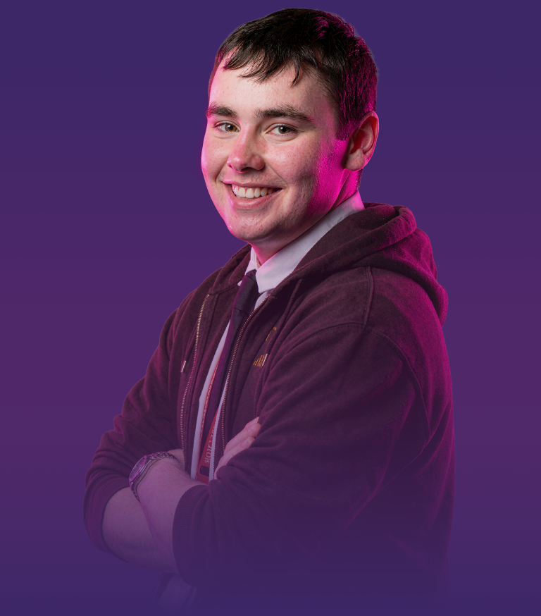 Student smiling at the camera with arms crossed